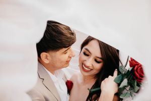 Tucson wedding photo of a bride and groom smiling under the bridal veil with soft romantic lighting.