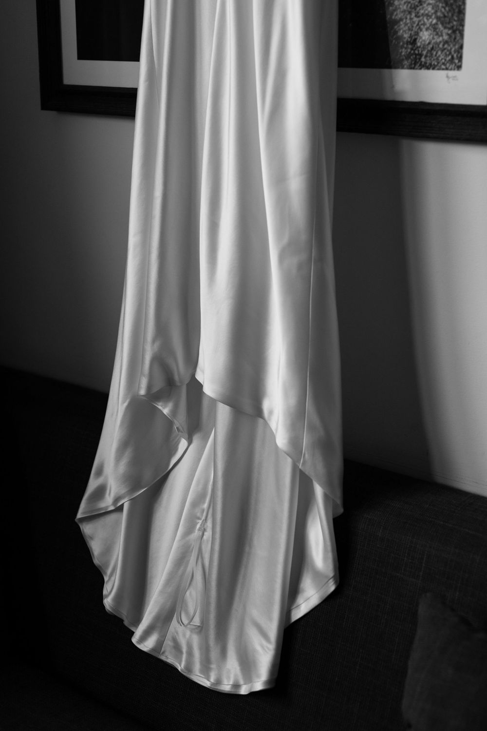 Detail shot of flowing white wedding dress train in dramatic black and white.