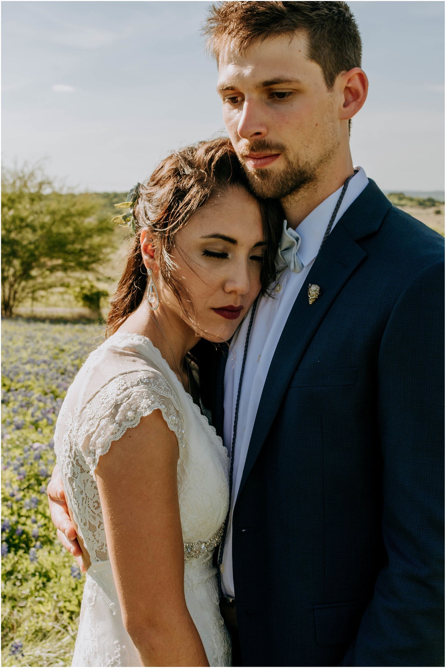 Romantic close-up portrait in golden sunlight with lace wedding dress details.