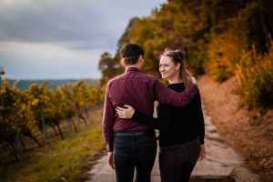 Romantic walk through autumn vineyard with mountains in background during golden hour.