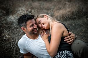 A tender embrace captured in an outdoor setting with natural lighting.
