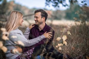 A couple sharing a tender moment during an autumn photoshoot in a rustic field.