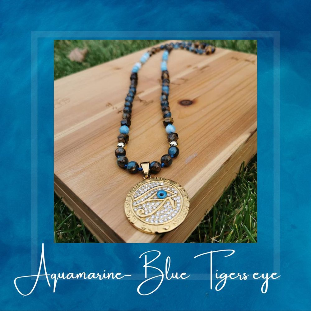 Aquamarine and blue tiger eye beaded necklace displayed on wooden surface.
