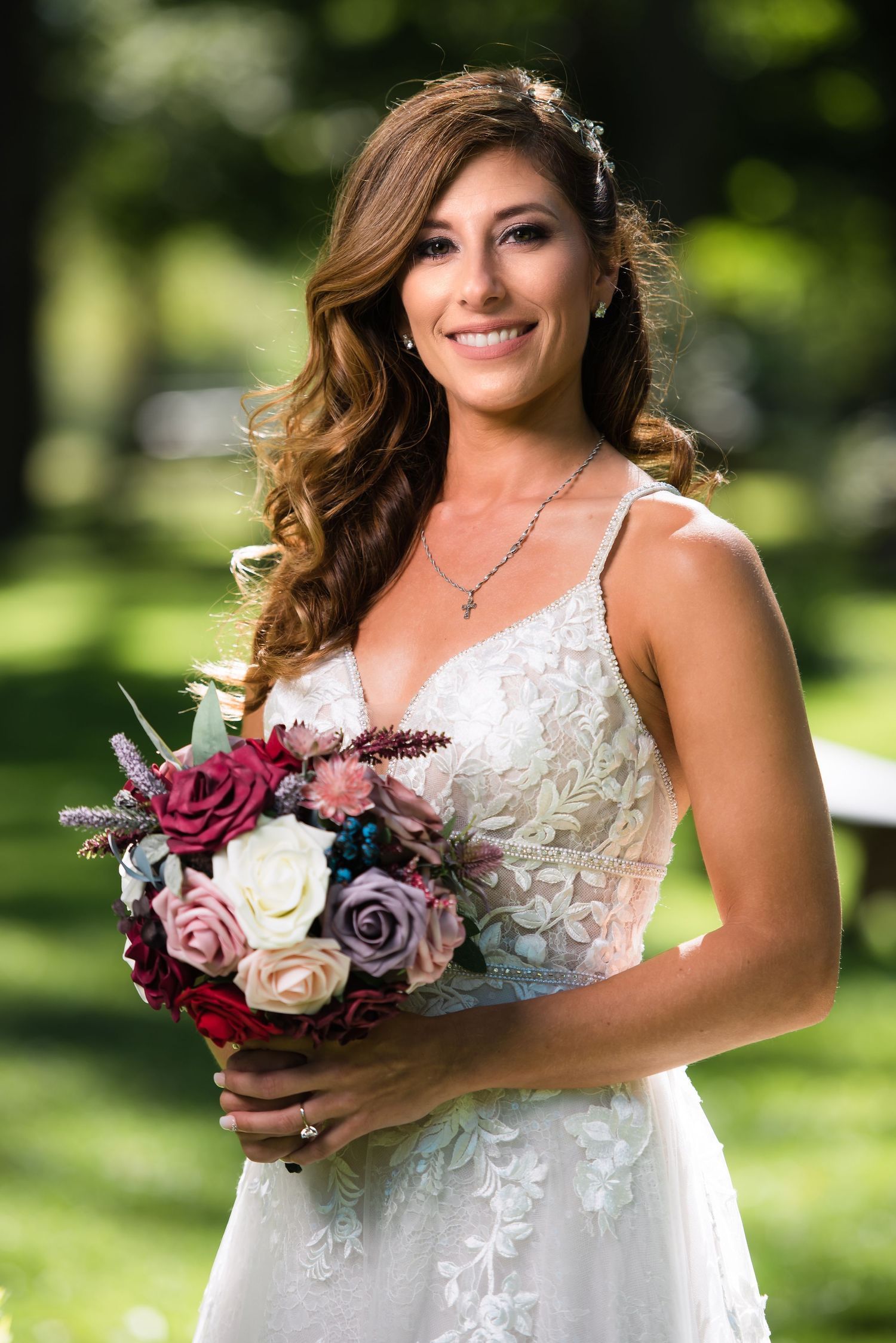 Elegant bridal portraits showcasing a white lace wedding dress and burgundy rose bouquet in a garden setting.