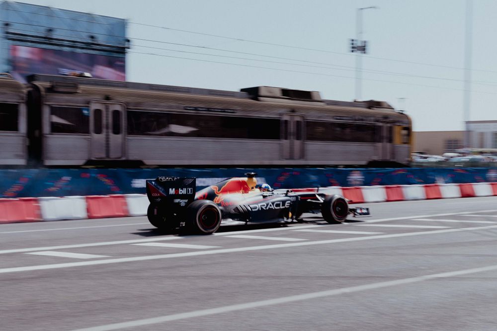 Formula 1 car speeding past on a street circuit with motion blur effect.