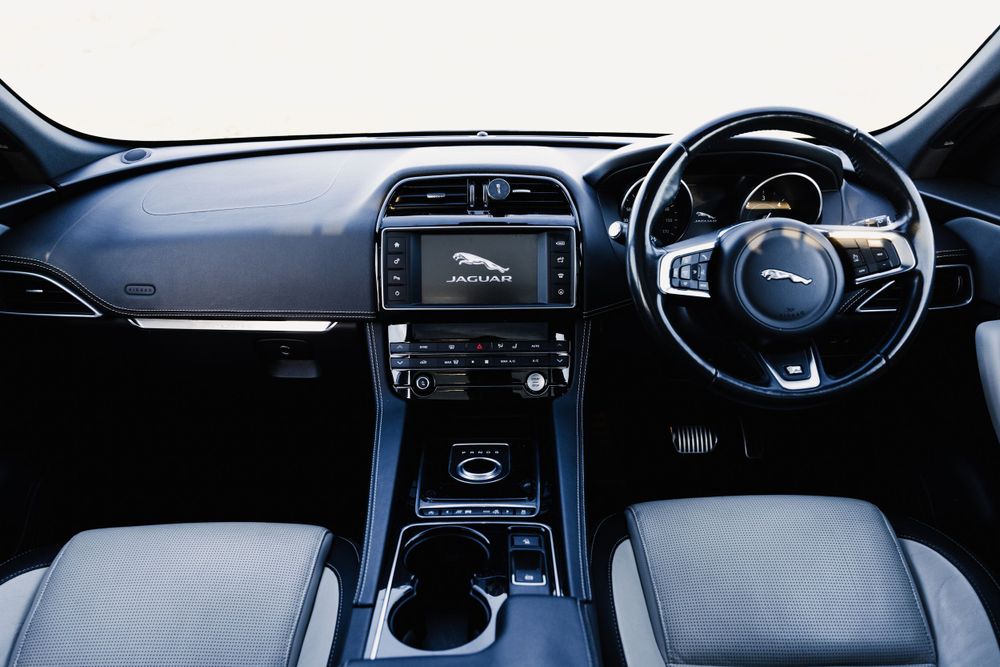 Modern luxury car interior dashboard showing sleek black design with digital displays and center console.