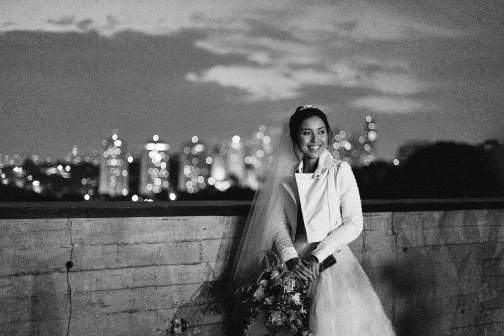 Dramatic nighttime bridal portrait with city lights twinkling in the background.