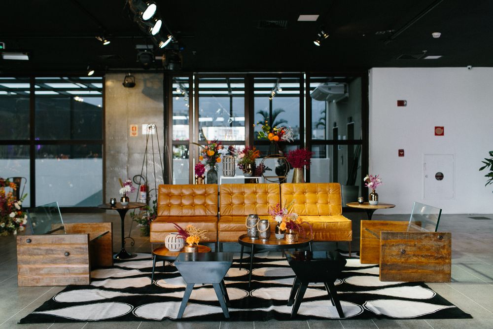 Modern industrial lounge area with yellow sofa and geometric rugs.