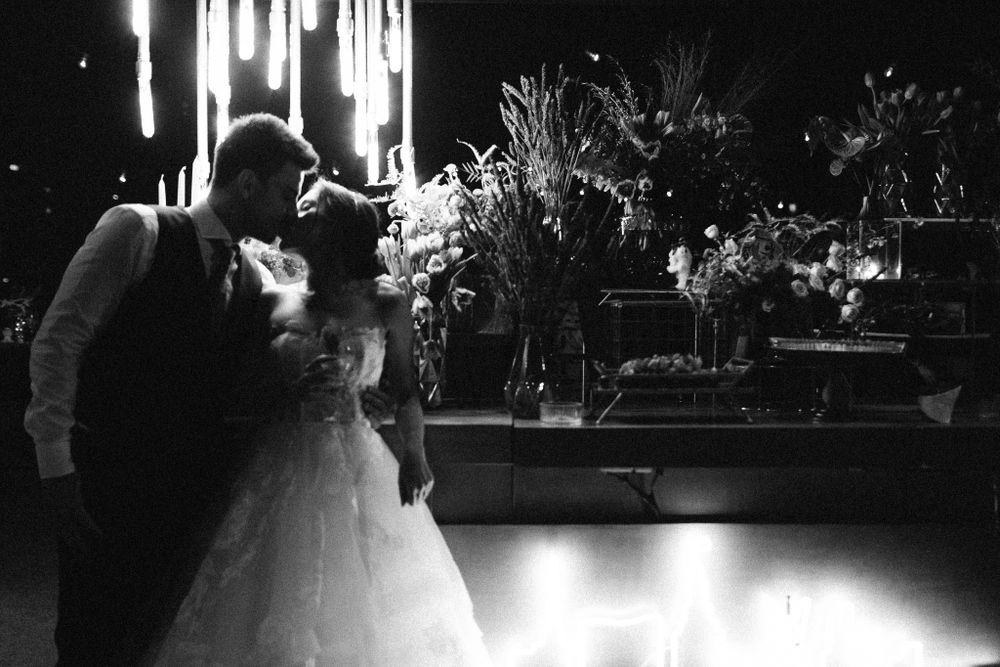 Silhouetted wedding couple sharing an intimate dance moment under dramatic lighting.
