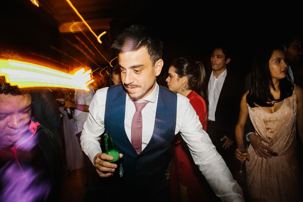 Wedding guest dancing at reception under colorful party lights.