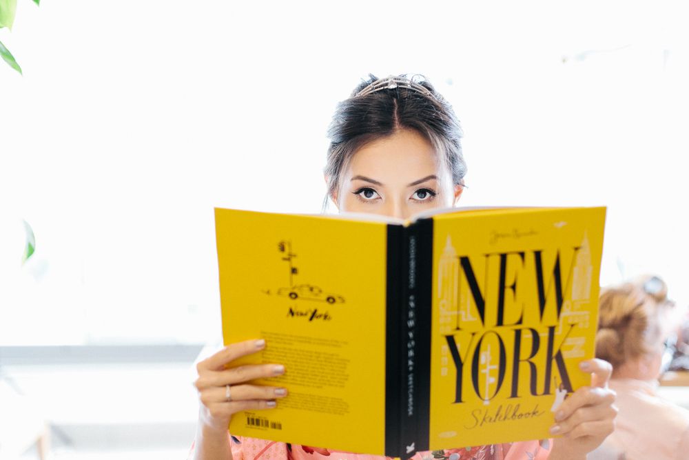 Someone reading a yellow New York magazine while peeking over the top.