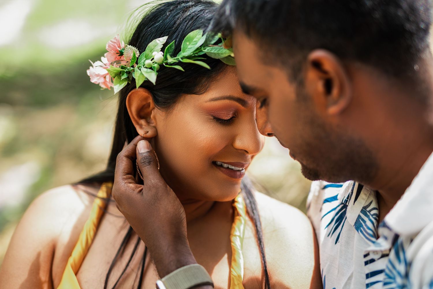 A tender romantic moment captured between a couple wearing traditional floral accessories.