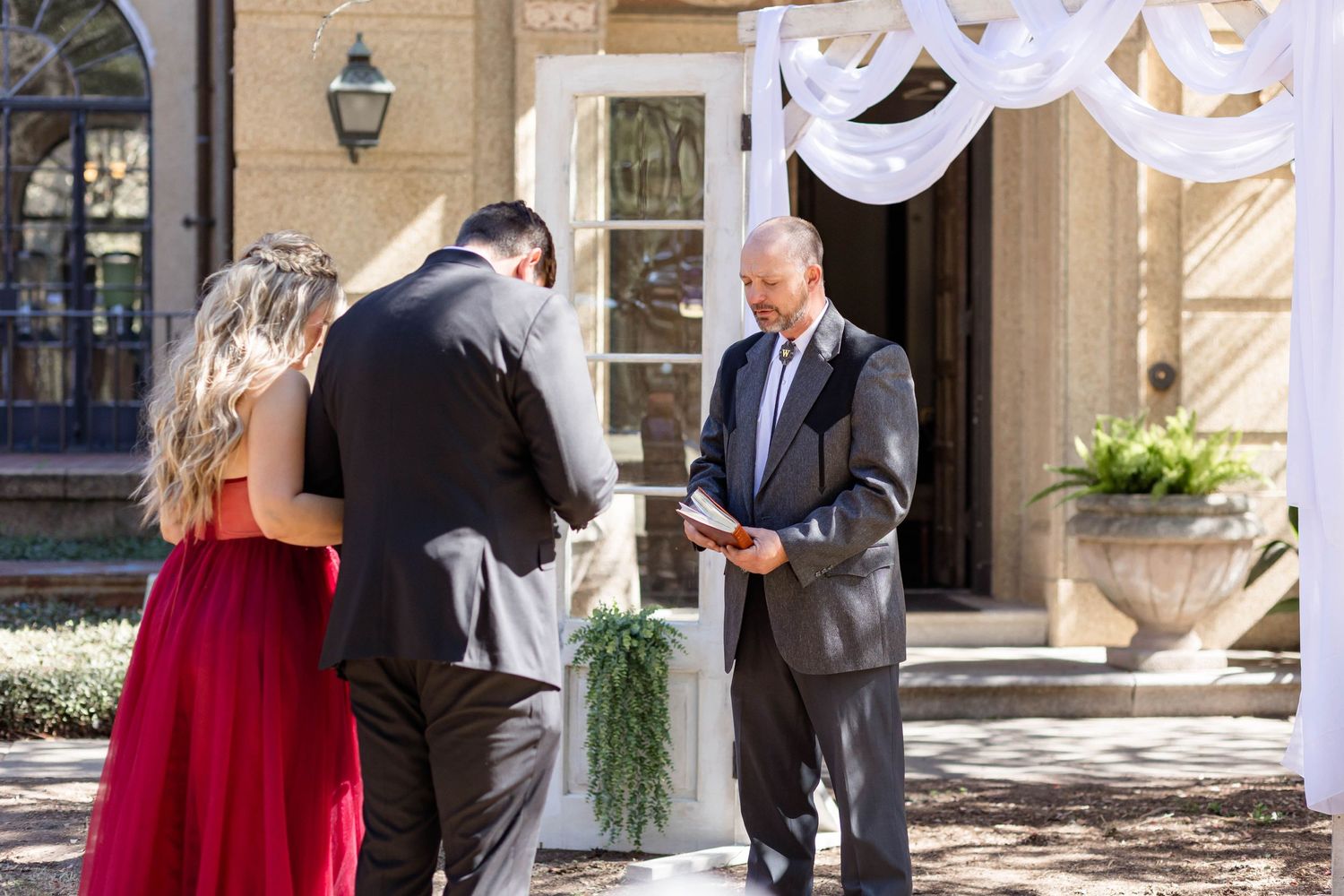 bride and groom pray with pastor