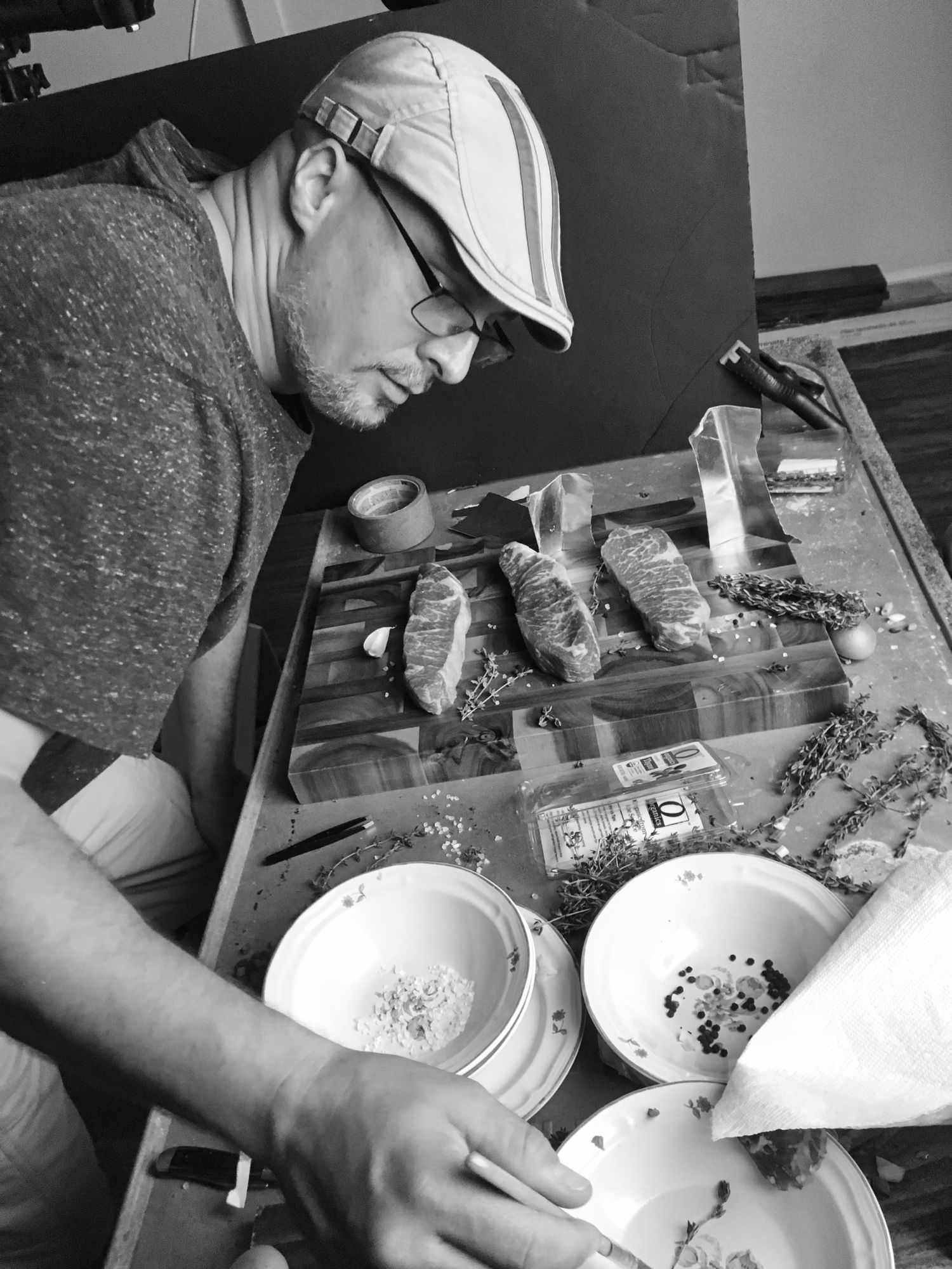 Black and white photo of food preparation with ingredients and bowls on a table.