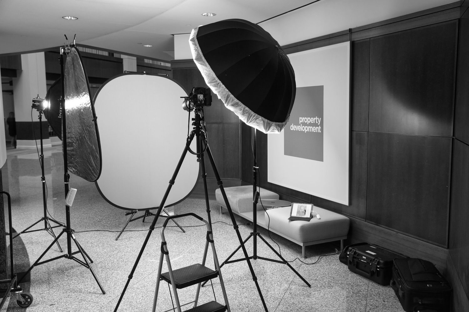 Professional photography studio setup with lights and reflectors in black and white.