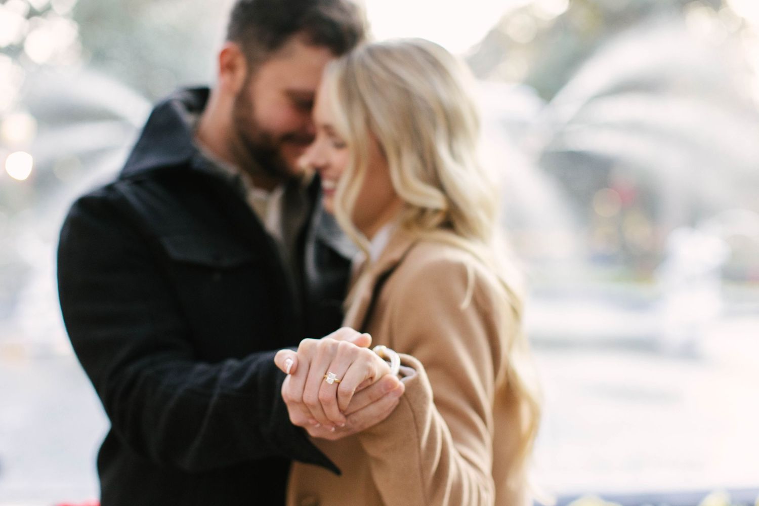 Tender embrace captured in soft focus during a winter engagement session.