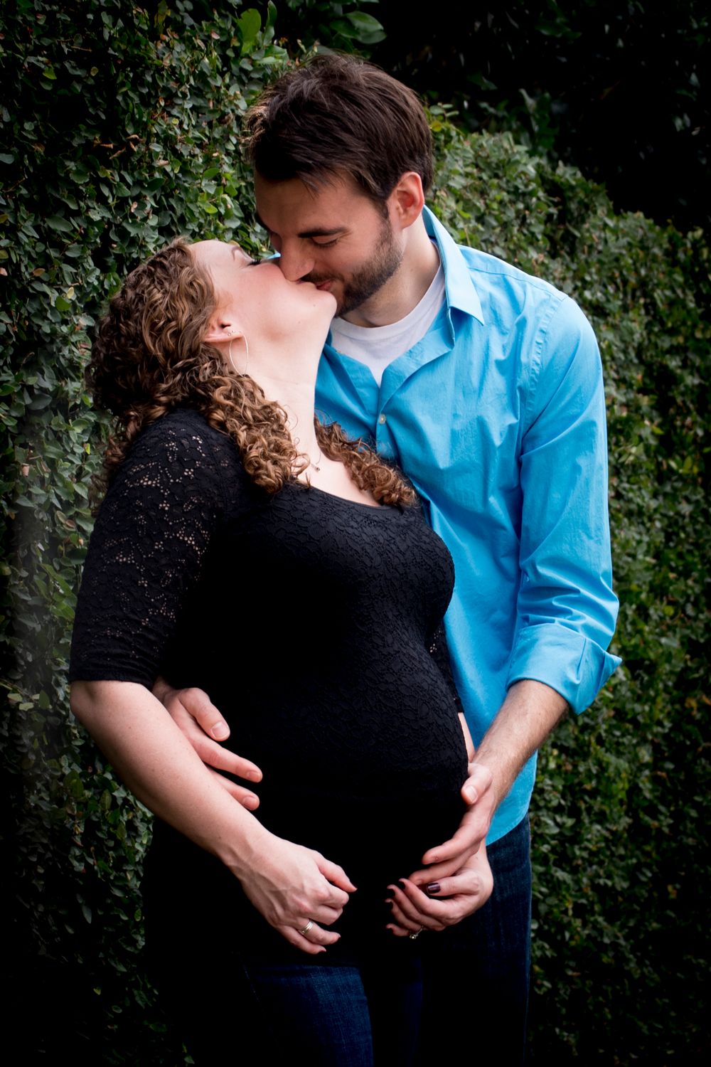 mother and father-to-be in love surrounded by trees during outdoor maternity photography session in Houston, Texas