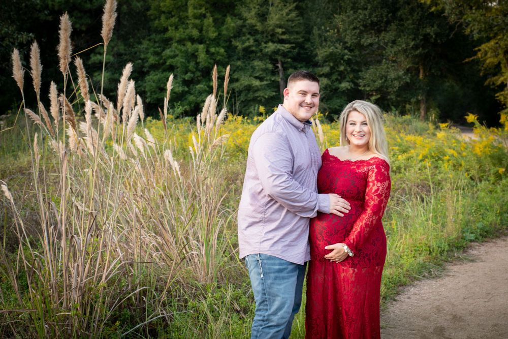 Expecting couple embracing during maternity photography session at the Houston Arboretum in Houston, Texas.