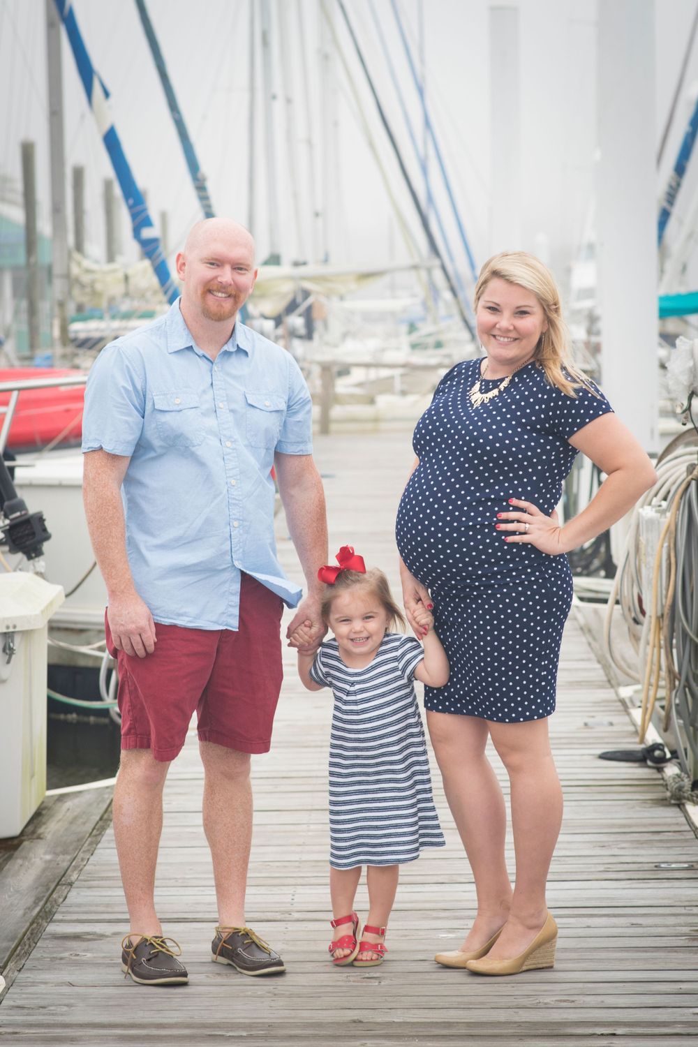 boats, baby, and more. Expecting mother, father, and little sister, during Houston maternity photography session at boat dock in Houston
