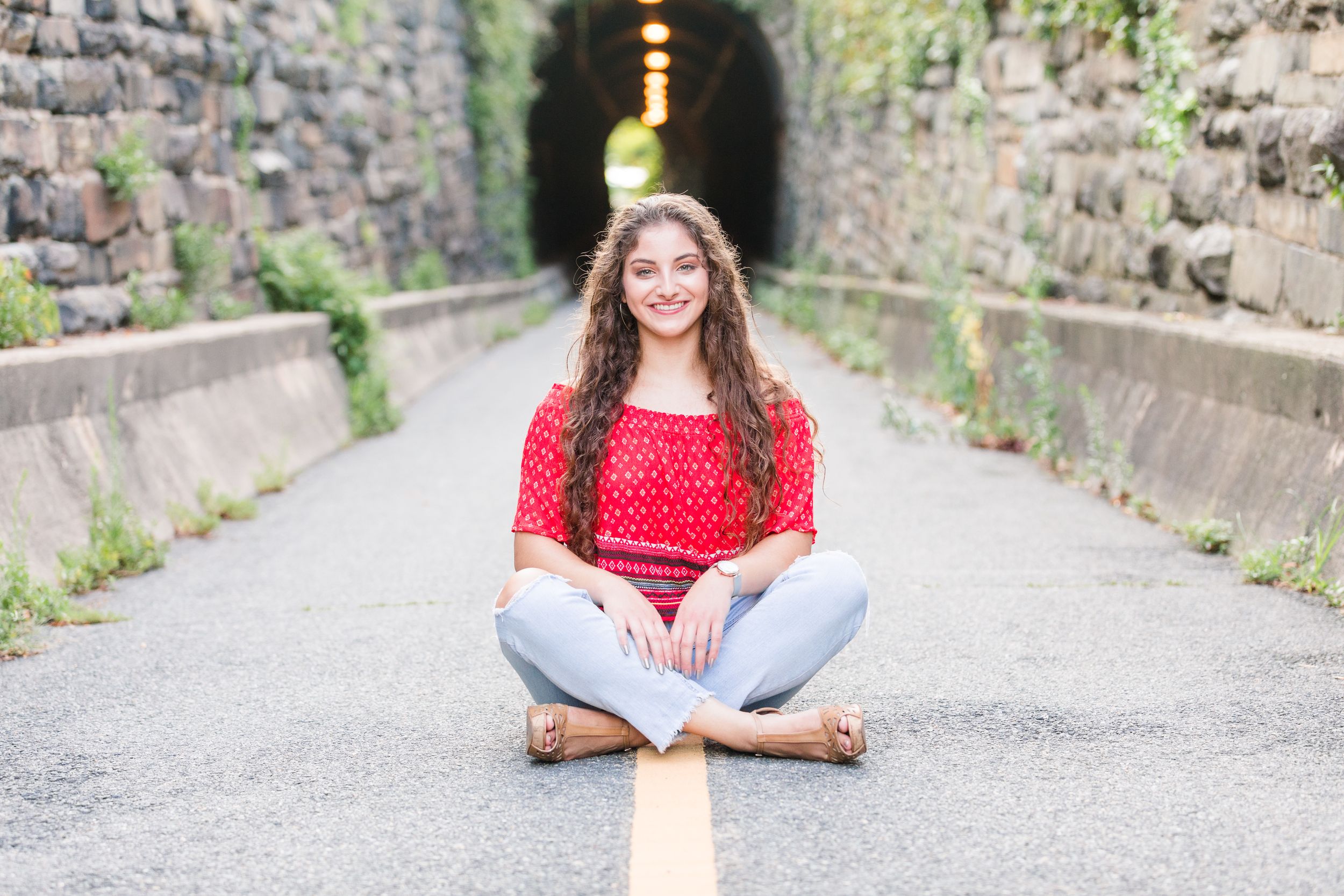 Senior girl sitting criss cross with Wilkes Tunnel in background
