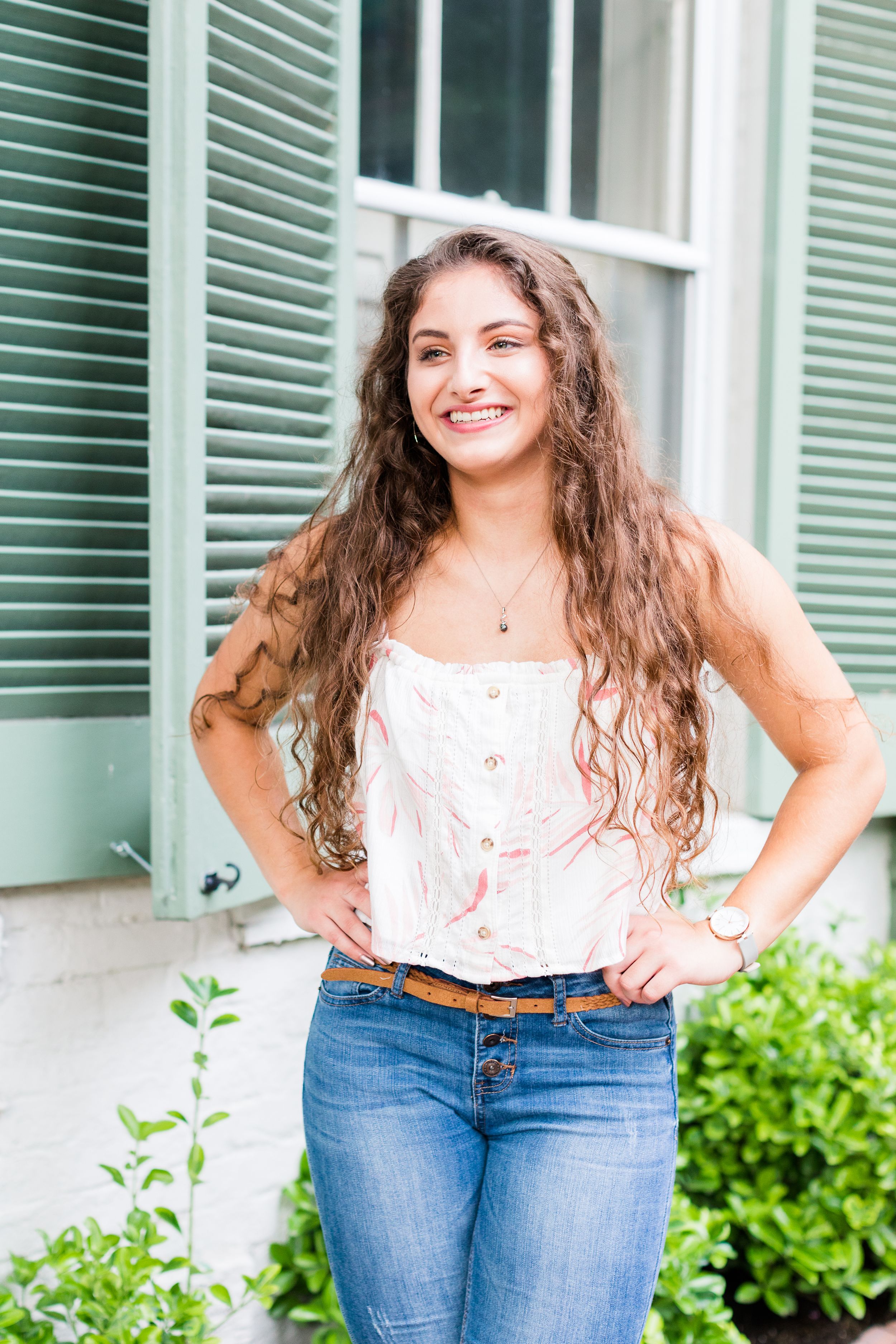 Senior girl posing in front of teal shutters on Prince Street Old Town Alexandria