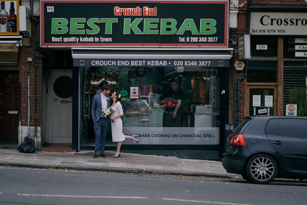 A couple stands in front of Best Kebab shop in Crouch End.