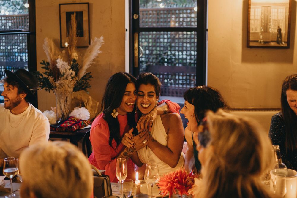 A celebratory dinner gathering with friends and wine at a warm-lit restaurant.