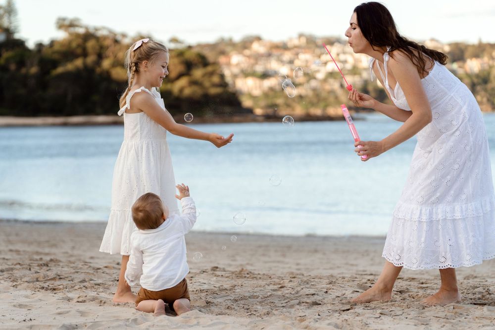family is blowing bubbles at a balmoral beach family photoshoot