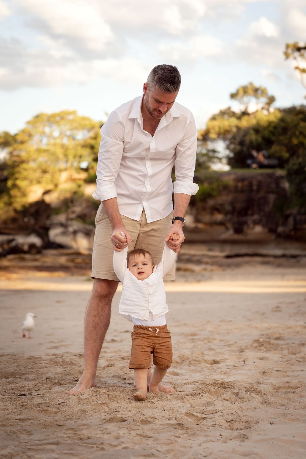Dad helps Son to walk at Balmoral Beach during a family photoshoot