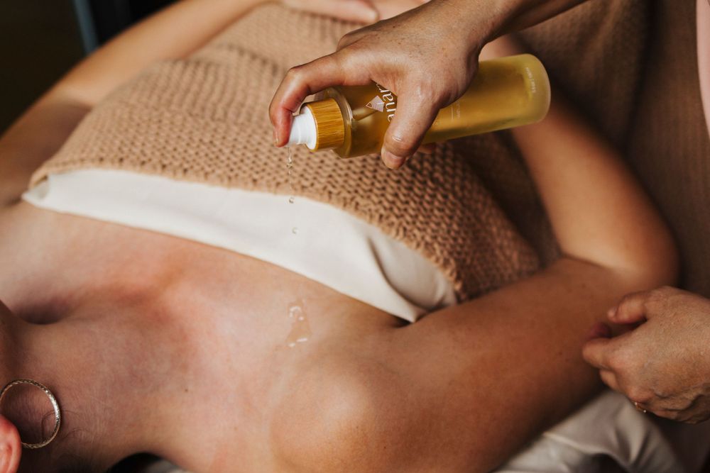 Massage oil being poured onto a person during a relaxing spa treatment session.