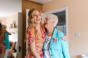 Joyful moment shared between two during wedding preparations.