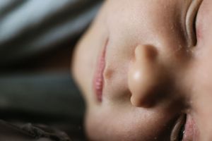 Extreme close-up of a nose and mouth in soft lighting.