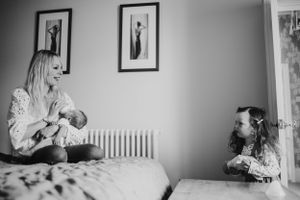 Tender family moment by a bright window in a nursery.