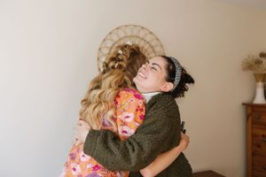 An emotional embrace shared during wedding day preparations.