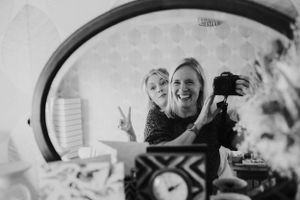 A reflection in a round mirror shows candid camera moments being captured.