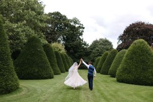 A couple dances among perfectly manicured topiary gardens during their wedding celebration.