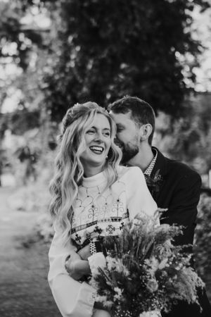 A black and white candid photo showing pure joy and laughter outdoors.