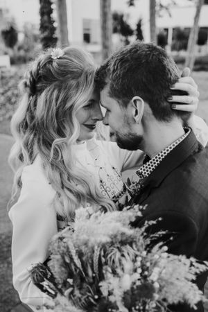 An intimate black and white portrait of a couple with dried flower bouquet.