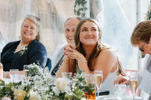 Wedding guests enjoying a festive reception dinner at a decorated table with flowers.