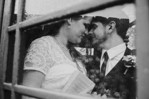 Romantic black and white portrait of a couple through window bars.