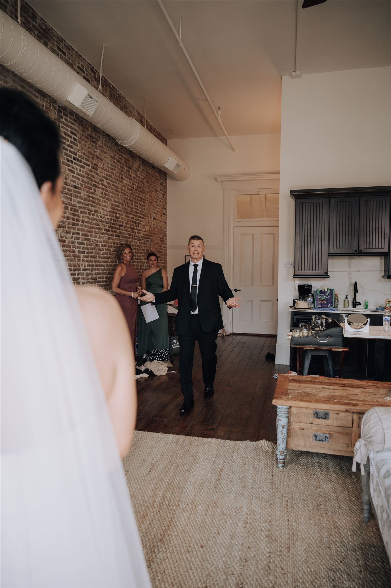 A wedding scene in a rustic loft space with exposed brick walls and casual decor.