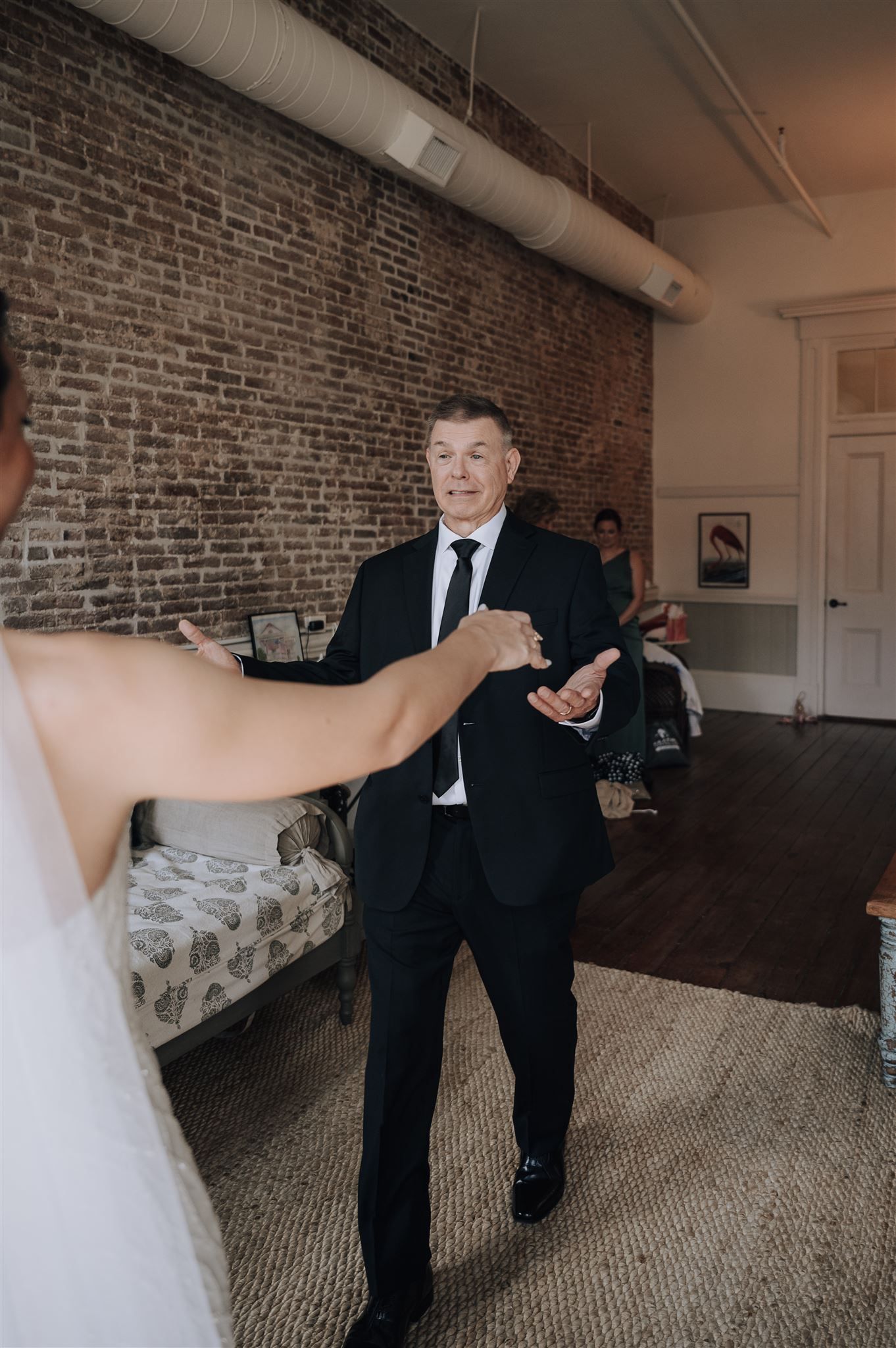 A celebratory wedding moment in an industrial-style room with exposed brick and ductwork.