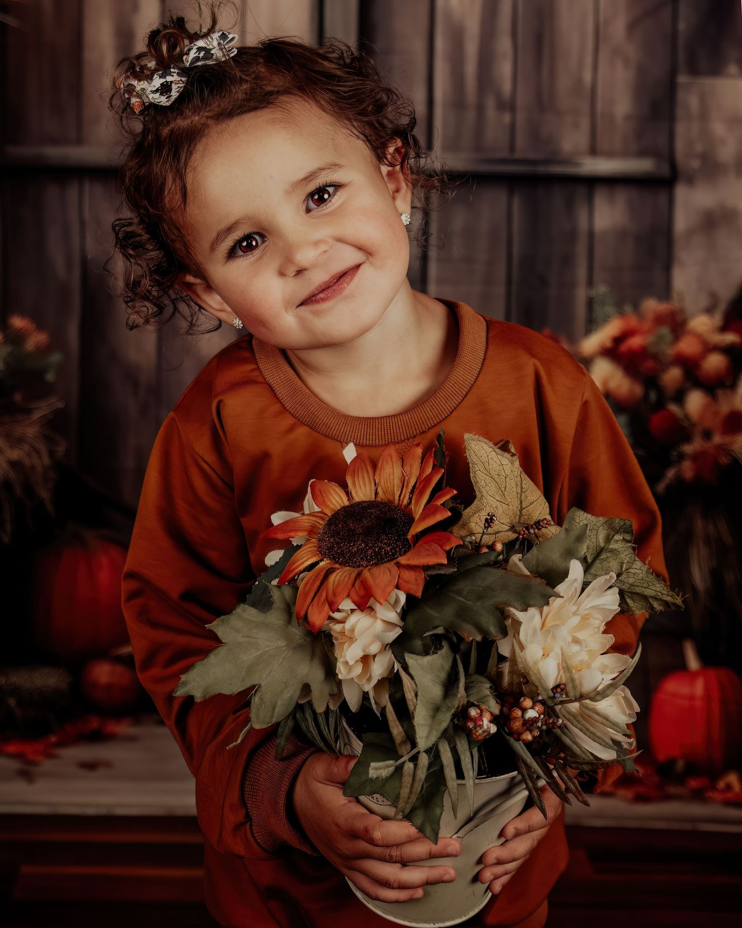 Autumn themed photo setup with sunflowers and fall decor against wooden backdrop.