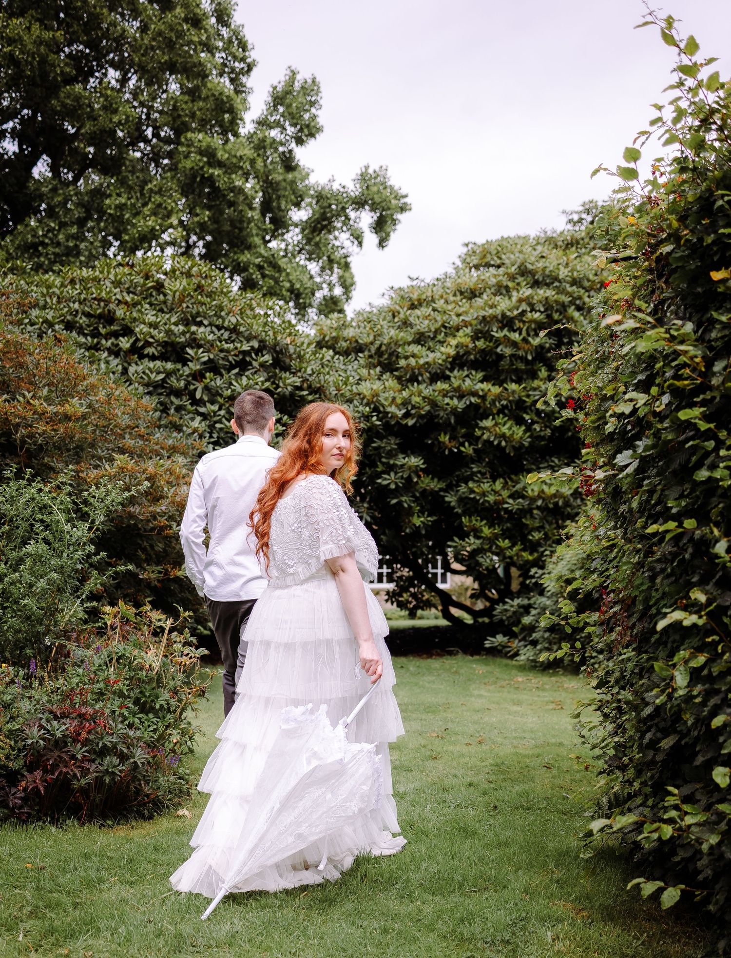 couple walking through the gardens once the rain has stopped Cumbria wedding photographer