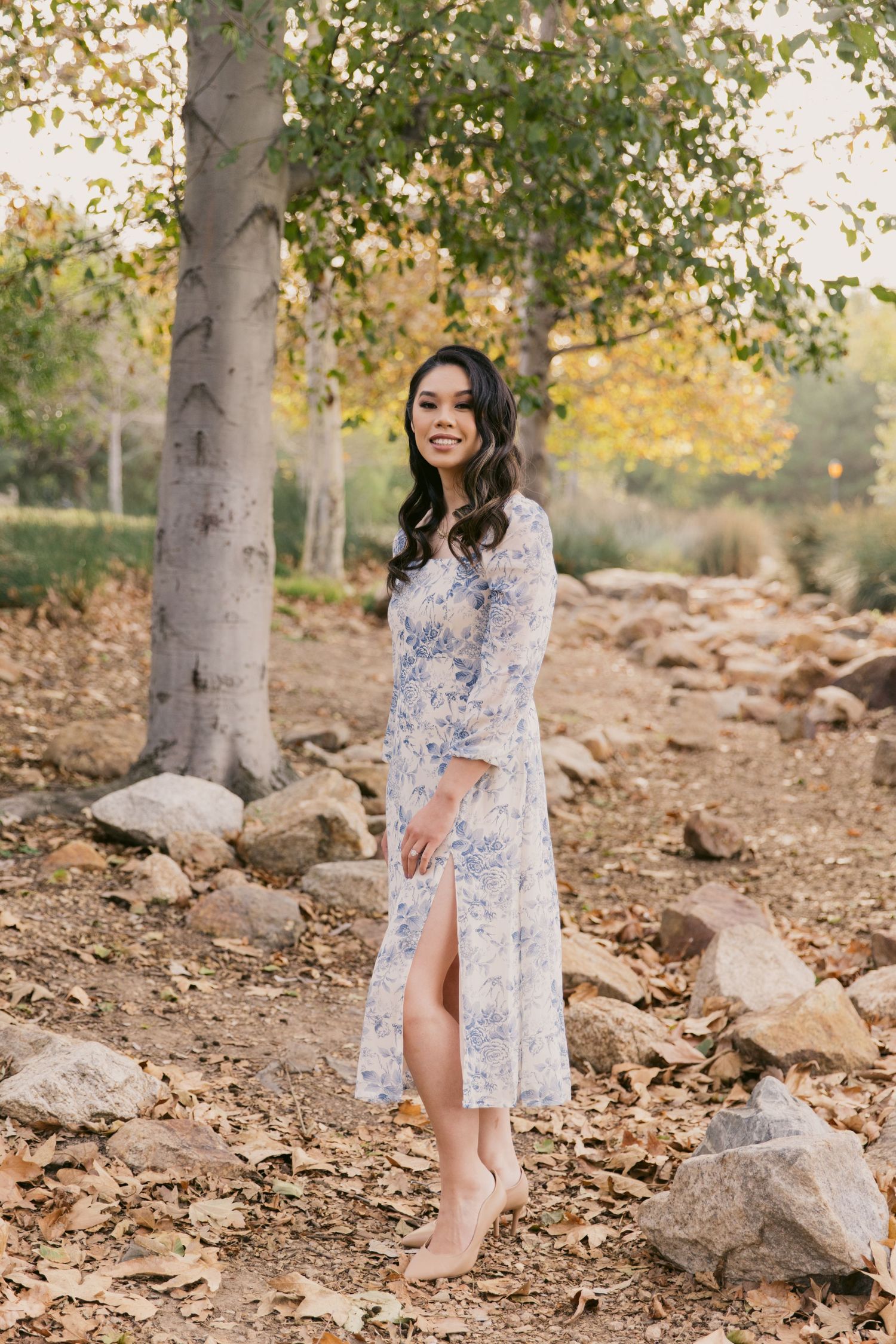 Romantic outdoor portrait session among autumn trees and fallen leaves.