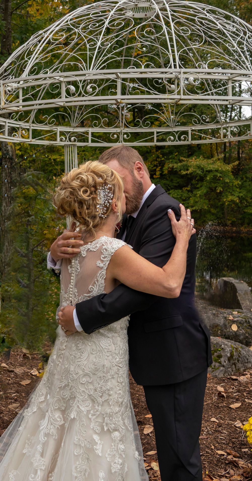 Bride and groom's first kiss in front of a gazebo