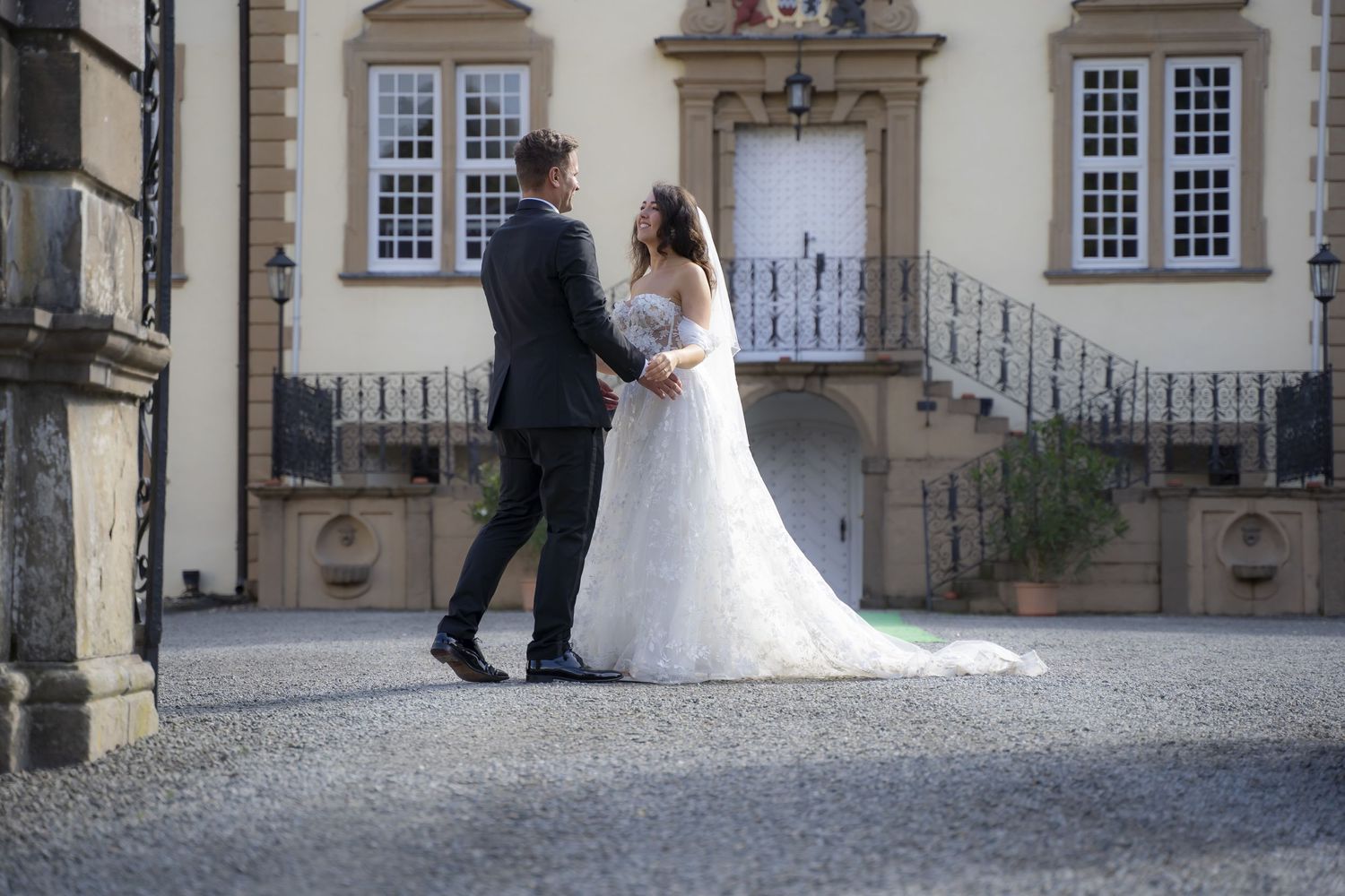 Elegant wedding ceremony outside historic building with stone architecture and windows.
