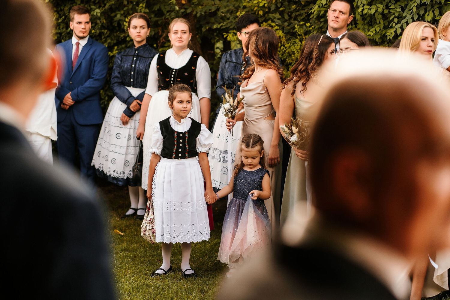 A gathering of people in traditional folk costumes at an outdoor celebration.