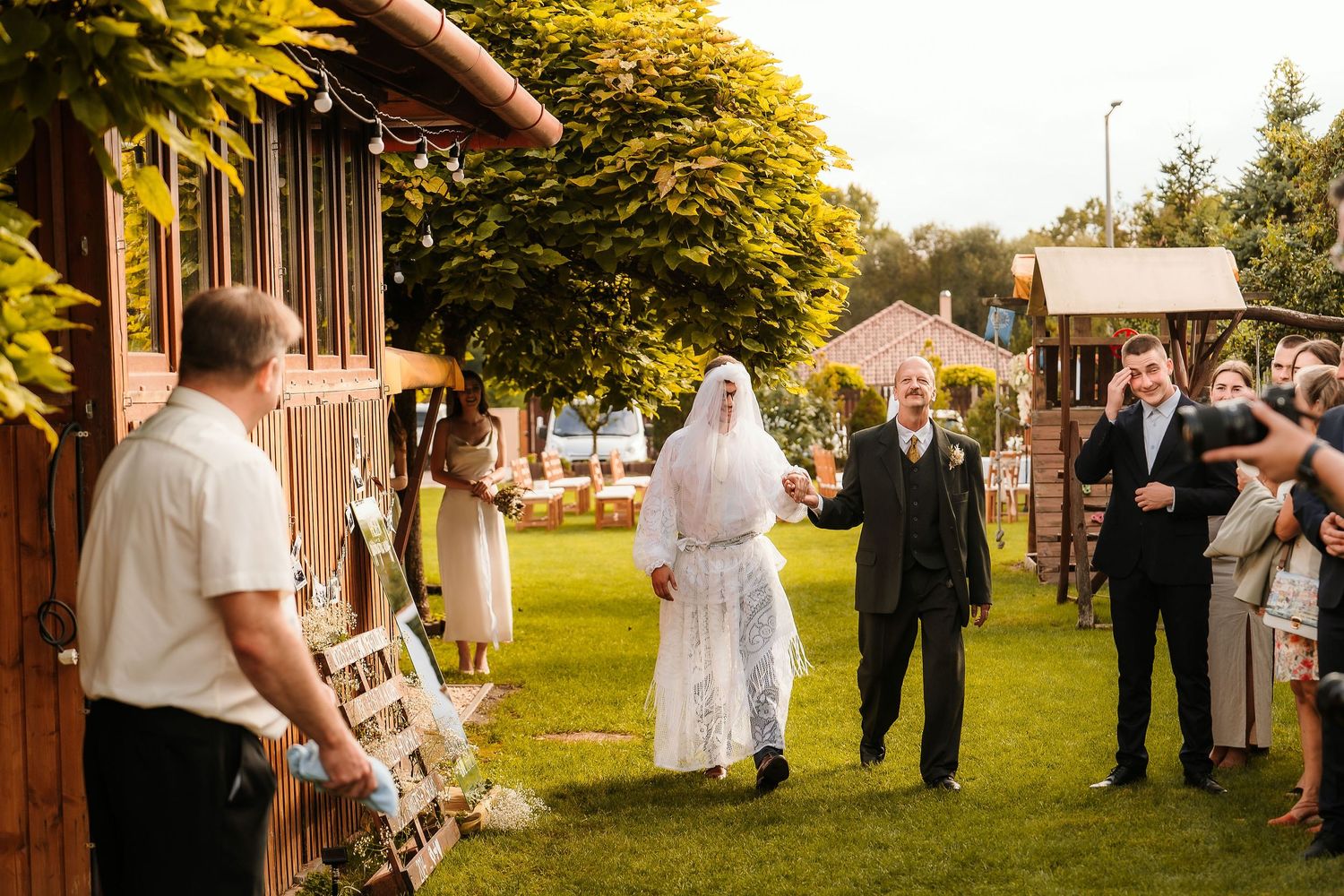 Wedding party and guests gathered outdoors for a festive celebration.