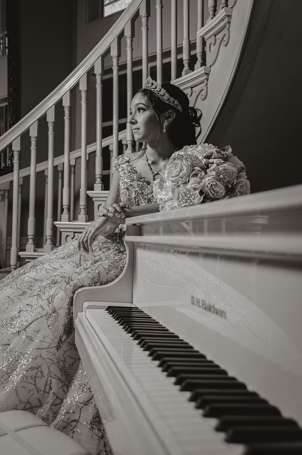 A black and white portrait showcasing a beaded gown and piano in classic composition.